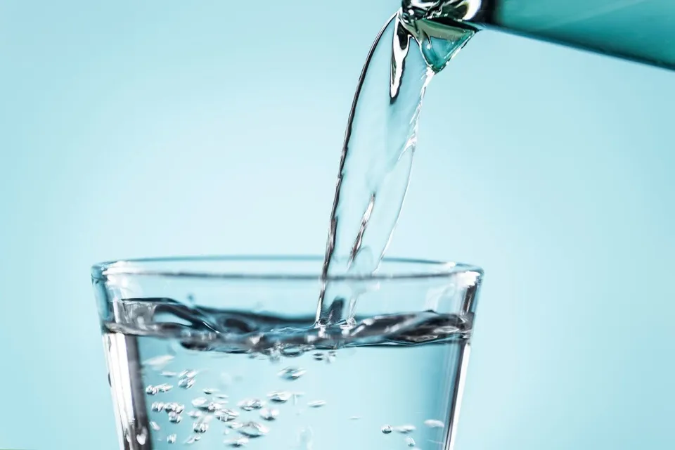 Close up shot of water being poured from pitcher into a water glass