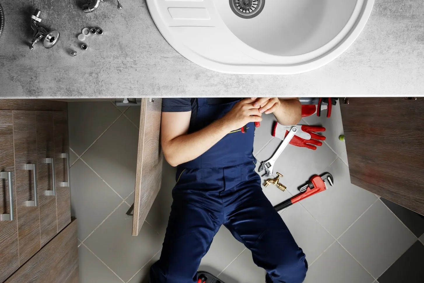 Overhead picture of a plumber working on bathroom sink