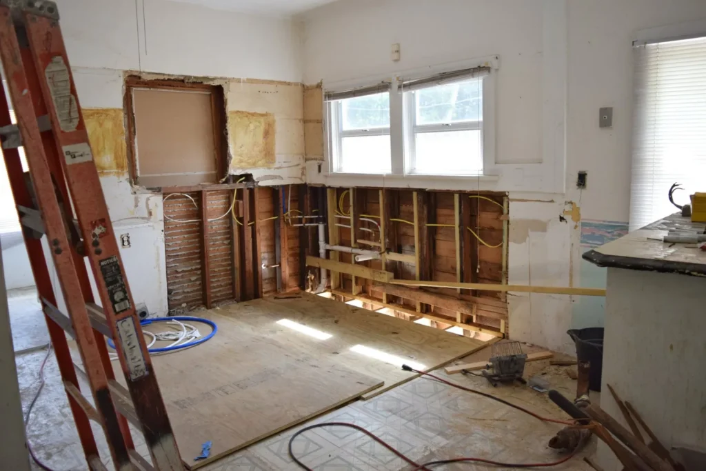 Kitchen in rough in remodeling phase with drywall taken out and all countertops, cabinets, appliances and fixtures removed