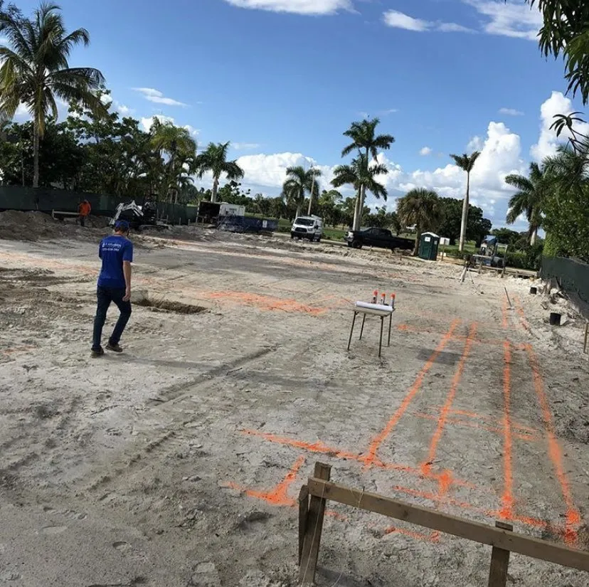 Plumber walking in a scraped land lot being prepared for a new home