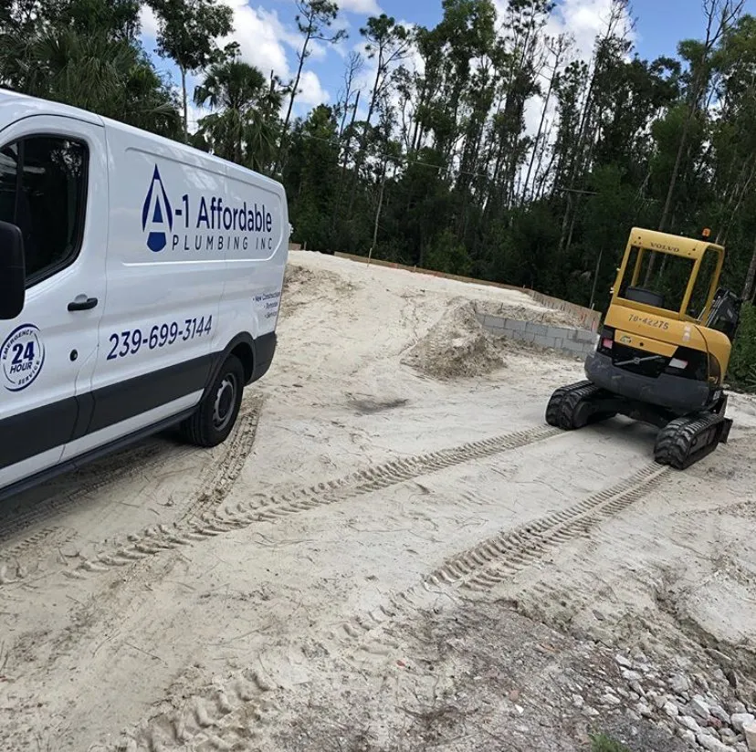 New construction site with mini excavator and A-1 Affordable plumbing work van parked in front of new foundation