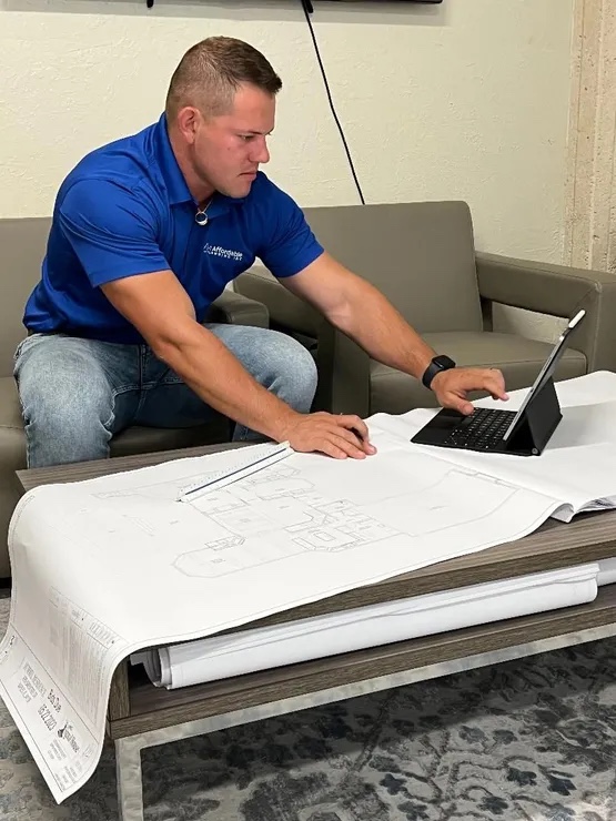 Owner of A-1 Affordable plumbing reviewing blueprints for commercial new construction project